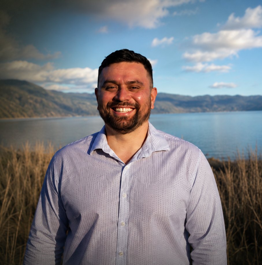 Aho Farms founder smiling, standing by a lake with hills behind